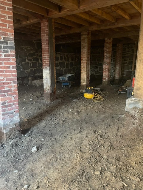 Old brick piers in Carriage House basement - the dusty white coating toward the base shows where moisture has been degrading and weakening the columns